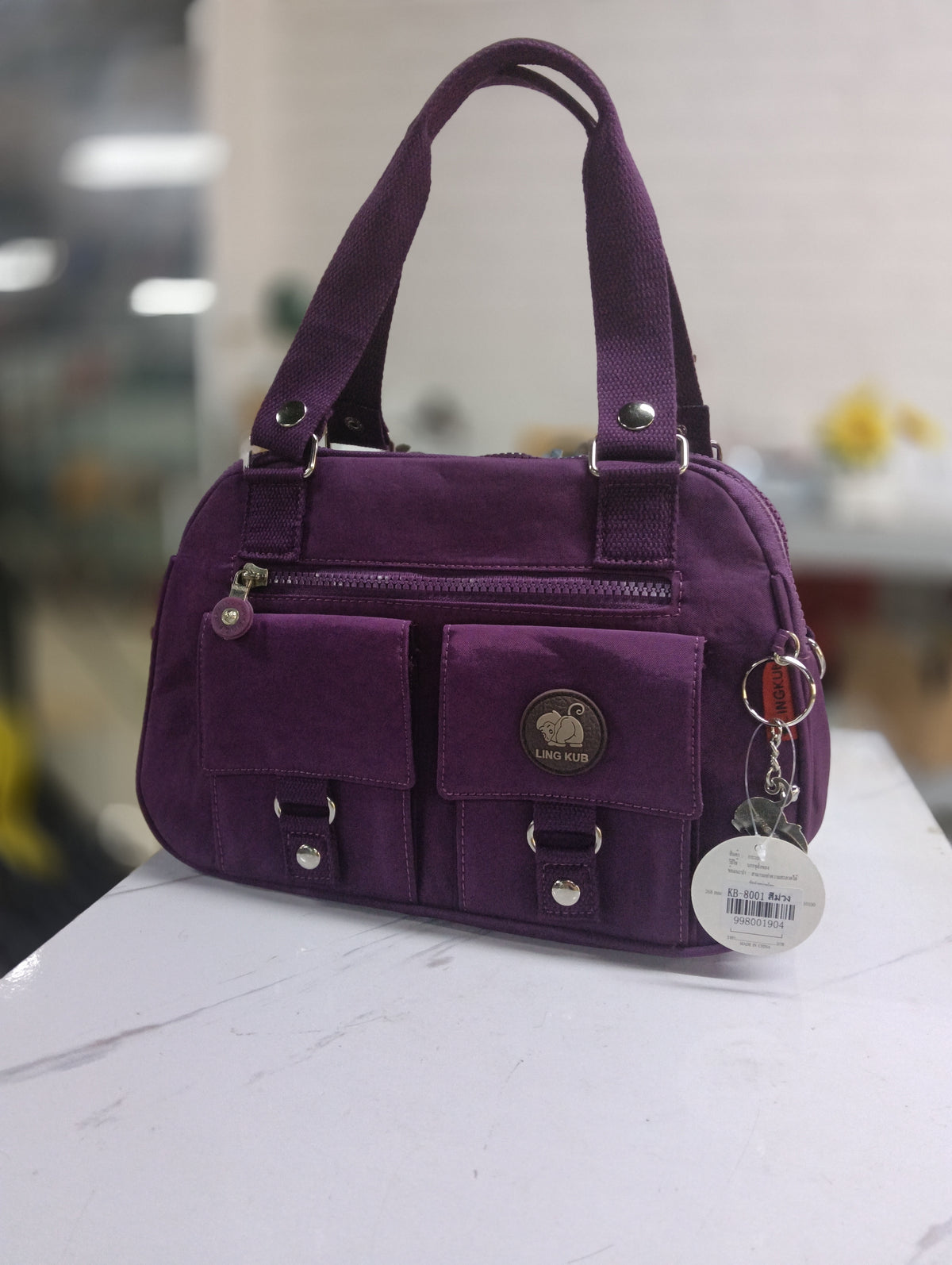 LING KUB KB-8001 purple sample bag with twin handles, front zip pocket and two flap pockets; original photograph.